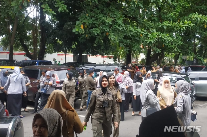 [마카사르(인도네시아)=AP/뉴시스]인도네시아 남술라웨시주 마카사르 정부청사에서 지진 발생으로 대피한 사람들이 건물 밖에 모여 있다. 인도네시아 플로레스섬에서 14일 규모 7.3의 해저 지진이 발생, 인도네시아 기상청이 쓰나미((지진 해일) 경보를 내렸다. 2021.12.14