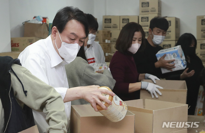 [서울=뉴시스] 국회사진기자단 = 윤석열 대통령이 대선 후보 시절 한부모 가정에게 보낼 물품을 포장하고 있다. 2021.12.15. photo@newsis.com