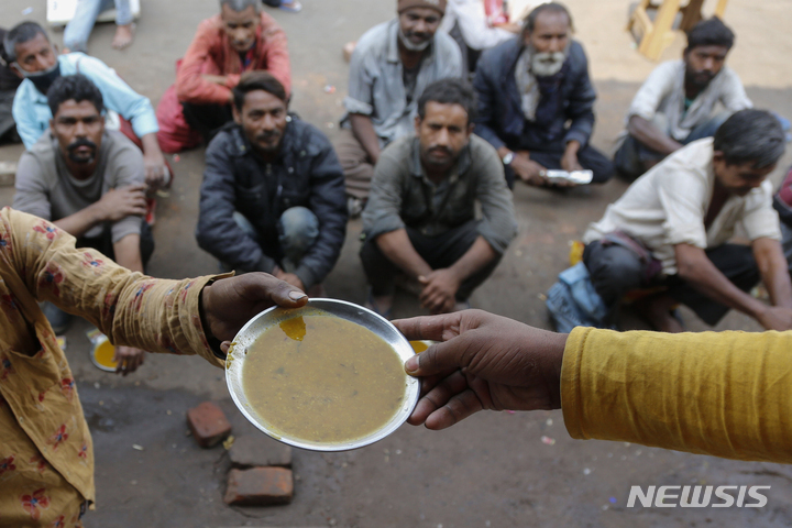 [뉴델리(인도)= AP/뉴시스]인도 아메다바드 시내의 한 무료급식소 대기자들. 인도는 식량부족으로 곡물수출을 금지, 세계 곡물가 급등에 일조했다.&nbsp; 