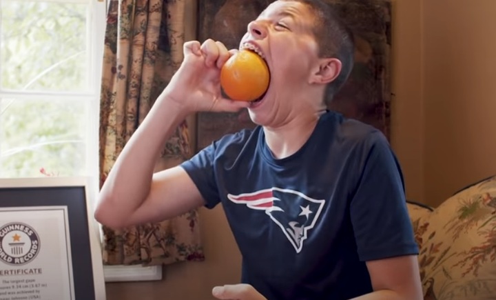 [서울=뉴시스] 미국 미네소타주 아이작 존슨(16)이 지난 6월 세계에서 가장 입이 큰 소년에 올랐다. 아이작은 기네스북과의 인터뷰에서 오렌지를 입에 넣어 보이고 있다. (출처 : 기네스북 유튜브 홈페이지) 2021.12.16. *재판매 및 DB 금지