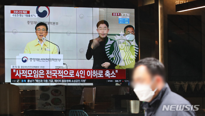 [서울=뉴시스] 권창회 기자 = 정부가 코로나19 확산을 막기 위해 거리두기 강화 대책을 발표한 지난 16일 오후 서울 시내 한 식당에서 방역 강화조치 관련 뉴스가 나오고 있다. 정부는 18일부터 16일간 사적모임 인원을 최대 4명까지 축소하고 유흥시설과 식당·카페는 오후 9시까지 영업시간을 제한하는 방역 강화조치를 시행한다고 밝혔다. 2021.12.16. kch0523@newsis.com