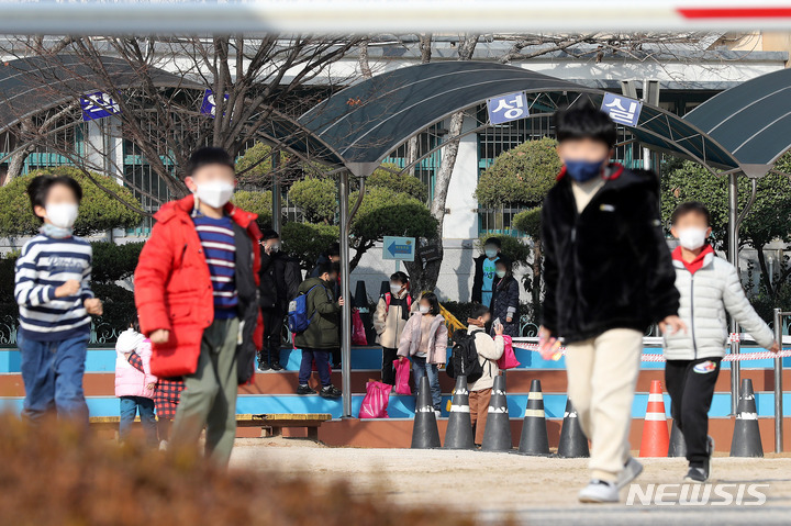 [서울=뉴시스] 백동현 기자 = 교육부가 방역 대응 강화 조치에 따른 학사운영 조치사항을 발표한 지난 16일 오후 서울 시내 한 초등학교에서 학생들이 하교하고 있다. 이날 교육부는 정부의 사회적 거리두기 재강화에 따라 수도권과 비수도권 과대학교·과밀학급의 전면등교를 약 한 달 만에 중단한다고 밝혔다. 초등학교는 6분의 5, 중·고교는 3분의 2로 밀집도를 다시 제한하며, 대학은 겨울 계절학기 수업 중 이론·교양·대규모 강의를 비대면으로 전환한다. 2021.12.19. livertrent@newsis.com