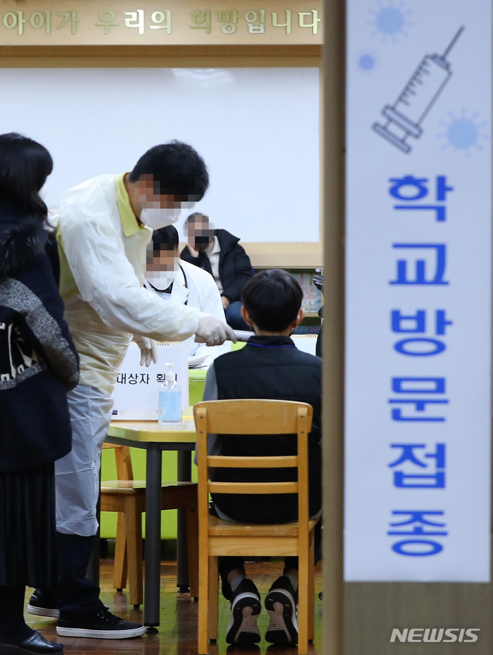 [부산=뉴시스] 하경민 기자 = 16일 오후 부산 부산진구의 한 초등학교 도서관에서 '찾아가는 백신접종'을 신청한 6학년 학생들이 코로나19 백신 접종에 앞서 예진 및 대상자 확인 과정을 거치고 있다. 2021.12.16. (사진공동취재단). photo@newsis.com