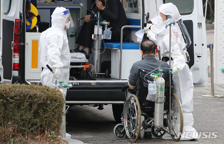 [서울=뉴시스] 권창회 기자 = 지난 16일 오후 서울 중랑구 서울의료원에서 코로나19 관련 위중증 환자가 의료진의 안내를 받아 이동하고 있다. 2021.12.16. kch0523@newsis.com