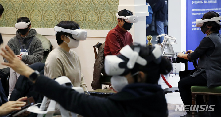 [서울=뉴시스] 홍효식 기자 = 'K-메타버스 엑스포 2021'이 열린 16일 서울 강남구 코엑스를 찾은 관람객들이 메타버스 체험을 하고 있다. 2021.12.16. yesphoto@newsis.com