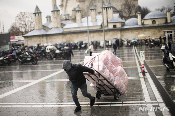 [이스탄불=AP/뉴시스] 지난 16일(현지시간) 터키 이스탄불의 전통 재래시장 그랜드 바자르 부근에서 한 남성이 수레로 짐을 나르고 있다. 터키 중앙은행이 식료품 등 기초생활용품을 사기도 어려운 소비자물가 급등에도 또다시 기준금리를 인하하면서 터키 리라화가 달러 대비 사상 최저치를 기록했다. 중앙은행은 인플레이션이 21%로 뛰고 있지만 금리를 15%에서 14%로 1.0% 포인트 인하했다. 2021.12.18.