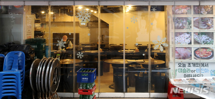 [서울=뉴시스] 추상철 기자 = 정부가 소상공인에게 손실보상과는 별도로 100만원의 방역지원금을 주기로 발표한 17일 오후 서울 중구 명동거리 한 음식점에서 손님이 없이 테이블만 놓여 있다. 2021.12.17. scchoo@newsis.com