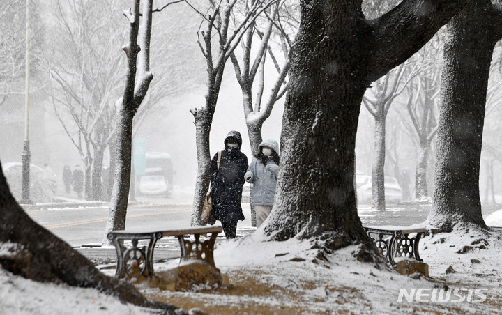 [광주=뉴시스] 변재훈 기자 = 광주·전남 곳곳에 대설특보가 내려진 17일 오후 광주 북구 용봉동 전남대학교 교정에 눈보라가 치는 가운데 두꺼운 외투를 입은 시민들이 걷고 있다. 2021.12.17. wisdom21@newsis.com