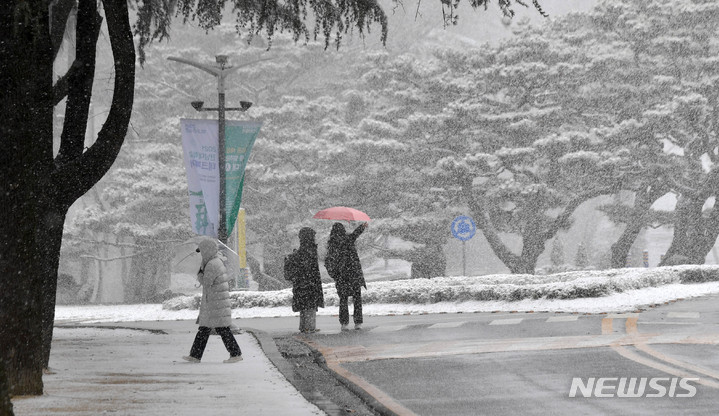 [광주=뉴시스] 변재훈 기자 = 광주·전남 곳곳에 대설특보가 내려진 17일 오후 광주 북구 용봉동 전남대학교 교정에서 시민들이 눈보라를 맞으며 걷고 있다. 2021.12.17. wisdom21@newsis.com