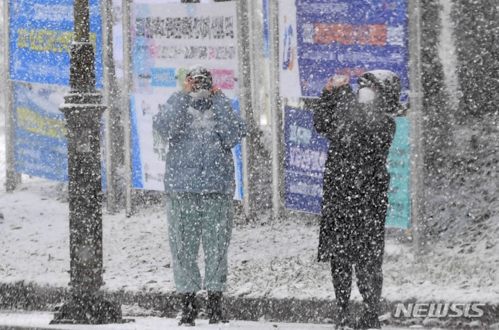 [광주=뉴시스] 변재훈 기자 = 광주·전남 곳곳에 대설특보가 내려진 17일 오후 광주 북구 용봉동 전남대학교 교정에 눈보라가 치는 가운데 시민들이 사진을 촬영하고 있다. 2021.12.17. wisdom21@newsis.com