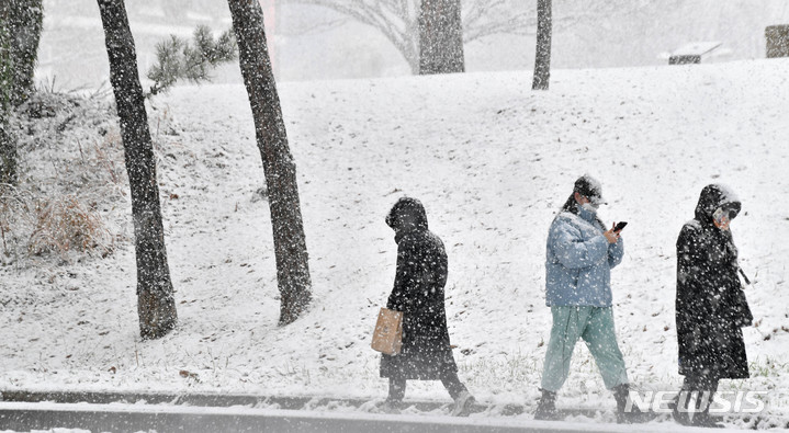 [광주=뉴시스] 변재훈 기자 = 광주·전남 곳곳에 대설특보가 내려진 17일 오후 광주 북구 용봉동 전남대학교 교정에 눈보라가 치는 가운데 두꺼운 외투를 입은 시민들이 걷고 있다. 2021.12.17. wisdom21@newsis.com