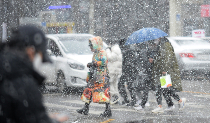 [광주=뉴시스] 김혜인 기자 = 광주·전남 곳곳에 대설특보가 내려진 17일 오후 광주 동구 금남로에서 시민들이 우산을 쓴 채 걷고 있다. 2021.12.17. hyein0342@newsis.com