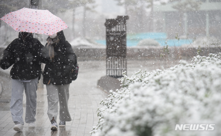 [광주=뉴시스] 김혜인 기자 = 광주·전남에 대설특보가 내려진 17일 오후 광주 동구 금남로에서 눈보라 사이로 시민들이 걷고 있다. 2021.12.17. hyein0342@newsis.com
