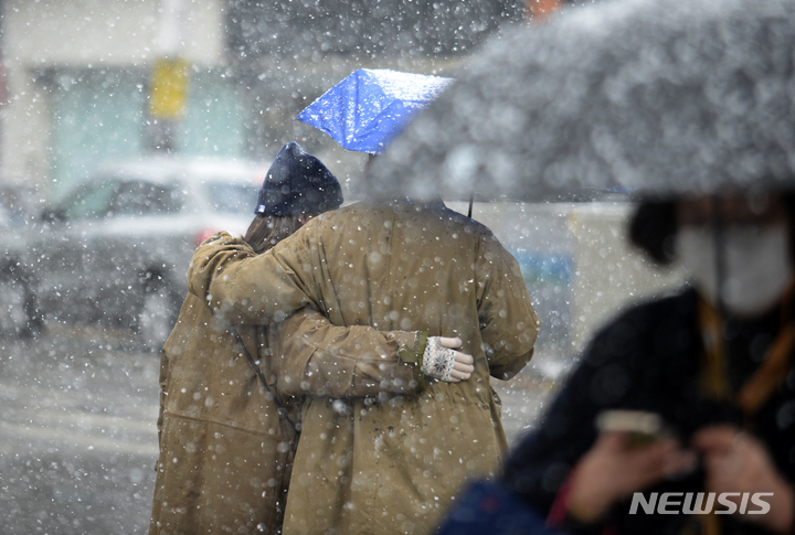 [광주=뉴시스] 김혜인 기자 = 광주·전남에 대설특보가 내려진 17일 오후 광주 동구 금남로에서 눈보라 사이로 시민들이 걷고 있다. 2021.12.17. hyein0342@newsis.com