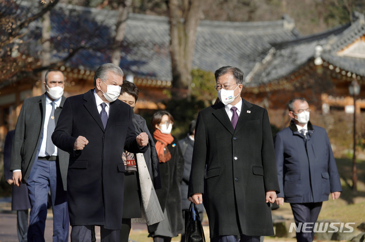 [서울=뉴시스] 김진아 기자 = 문재인 대통령과 샵카트 미르지요예프 우즈베키스탄 대통령이 17일 청와대에서 친교오찬을 마친 후 녹지원을 걸으며 대화를 나누고 있다. 2021.12.17. bluesoda@newsis.com