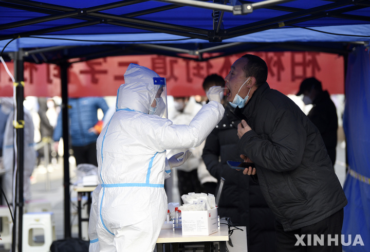 [시안=신화/뉴시스] 중국 산시성 성도 시안에 있는 코로나19 검사센터에서 17일 보건관계자가 주민의 샘플을 채취하고 있다. 2021.12.17 