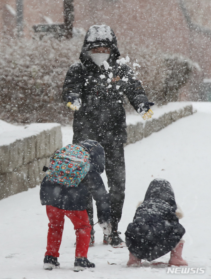 아빠도 반격이다[서울=뉴시스] 조수정 기자 = 올 겨울 첫 대설주의보가 발령된 18일 오후 서울 서대문구에서 어린이들이 엄마아빠와 눈싸움을 하고 있다. chocrystal@newsis.com