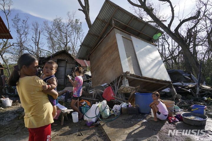 [세부(필리핀)=AP/뉴시스]필리핀 중부 세부에서 18일 주민들이 슈퍼 태풍 라이로 무너진 집 앞에 모여 있다. 올해 필리핀을 강타한 가장 강한 태풍 라이로 인한 사망자 수가 최소 146명으로 늘어난 가운데 통신 두절로 피해 보고가 이뤄지지 못하는 곳이 많아 피해는 더욱 늘어날 것이 확실시되고 있다. 2021.12.20