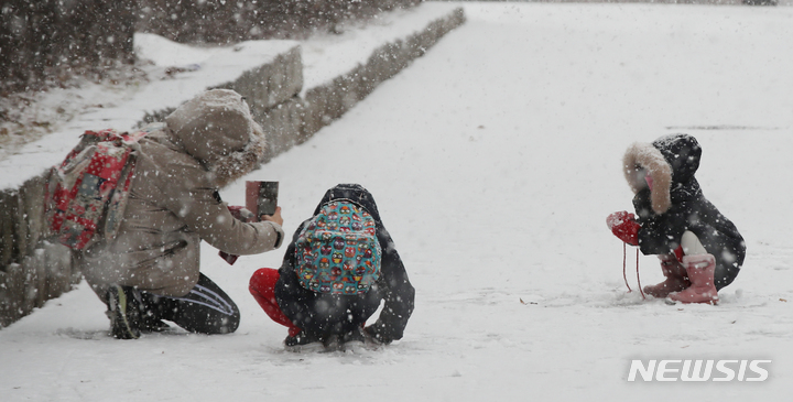 찰칵, 찰칵, 아이들 사진 찍는 엄마 "저희에겐 이 눈이 선물같아요"[서울=뉴시스] 조수정 기자 = 올 겨울 첫 대설주의보가 발령된 18일 오후 서울 서대문구에서 어린이들이 엄마아빠와 눈싸움을 하고 있다. chocrystal@newsis.com