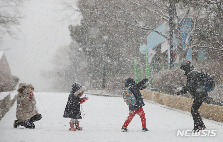 찰칵 찰칵! 바쁜 엄마 '예쁜 모습 담아놔야지'[서울=뉴시스] 조수정 기자 = 올 겨울 첫 대설주의보가 발령된 18일 오후 서울 서대문구에서 어린이들이 엄마아빠와 즐거운 시간을 보내고 있다. chocrystal@newsis.com