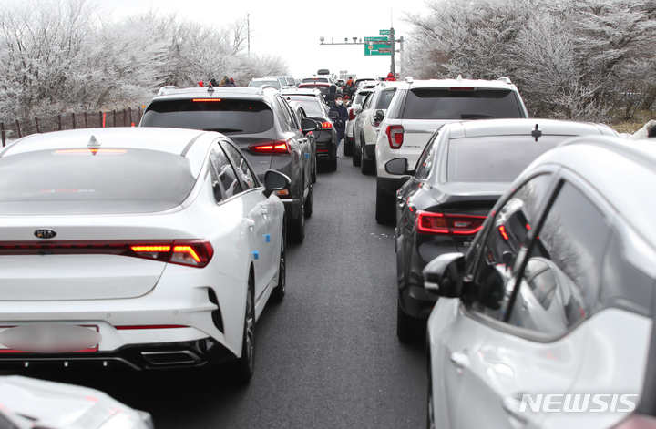 [제주=뉴시스] 우장호 기자 = 영하권의 추위가 서서히 누그러진 19일 오후 제주 한라산 1100고지에 핀 상고대를 감상하기 위한 차량 행렬이 이어지고 있다. 2021.12.19. woo1223@newsis.com