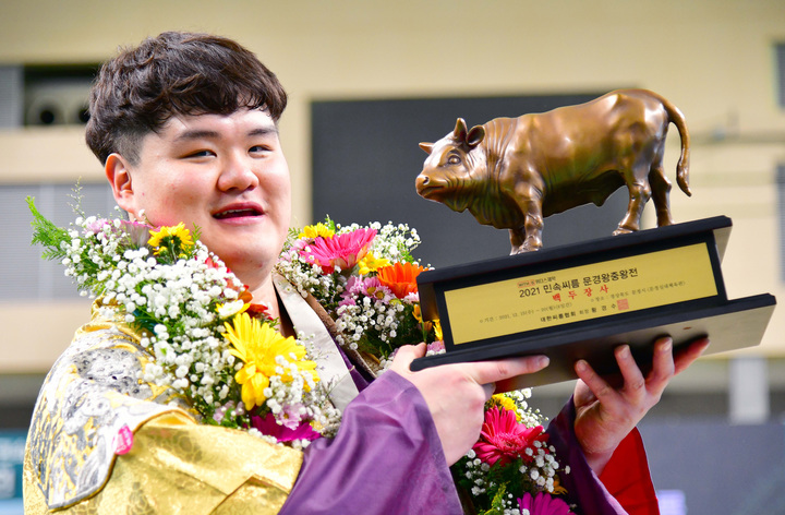 [서울=뉴시스] 19일 경북 문경실내체육관에서 열린 ‘위더스제약 2021 민속씨름 문경왕중왕전’에서 백두장사(140kg이하)에 등극한 장성우(영암군민속씨름단)가 황소트로피를 들고 기념촬영하고 있다. (사진=대한씨름협회 제공) 2021.12.19. photo@newsis.com *재판매 및 DB 금지