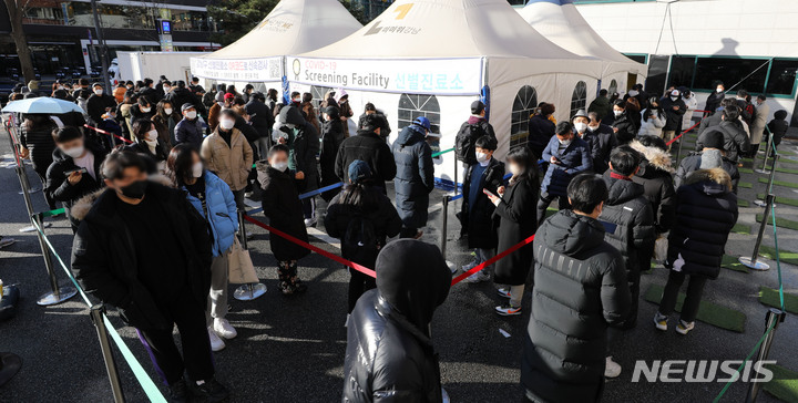 [서울=뉴시스] 지난 19일 오후 서울 강남구 보건소 선별진료소에서 시민들이 검사를 받기 위해 대기하고 있다. 2021.12.19. kch0523@newsis.com