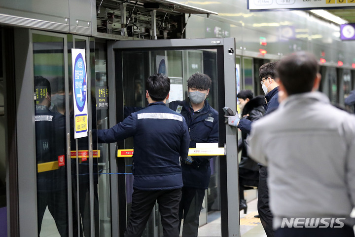 [서울=뉴시스] 백동현 기자 = 20일 오전 서울 성동구 왕십리역 5호선에서 역내 관계자들이 전국장애인차별철폐연대의 장애인 이동권 보장 시위 중에 파손된 승강장 안전문을 붙잡고 있다. 2021.12.20. livertrent@newsis.com