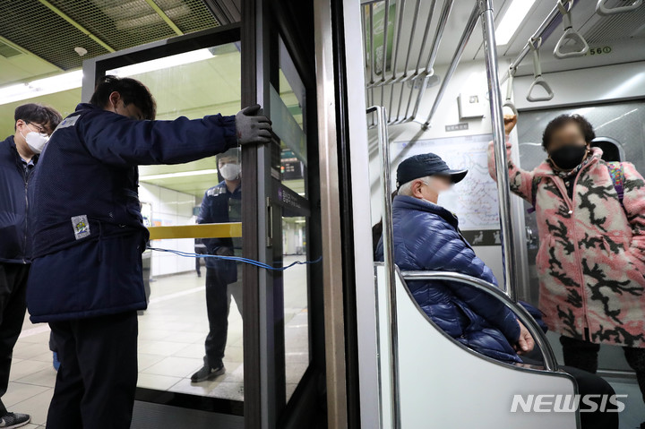 [서울=뉴시스] 백동현 기자 = 20일 오전 서울 성동구 왕십리역 5호선에서 역내 관계자들이 전국장애인차별철폐연대의 장애인 이동권 보장 시위 중에 파손된 승강장 안전문을 붙잡고 있다. 2021.12.20. livertrent@newsis.com