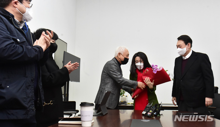 [서울=뉴시스] 국회사진기자단 = 윤석열 국민의힘 대선 후보가 20일 서울 여의도 새시대준비위원회 사무실에서 새시대준비위 수석부위원장으로 합류한 신지예 한국여성정치네트워크 대표 환영식을 하고 있다. 2021.12.20. photo@newsis.com