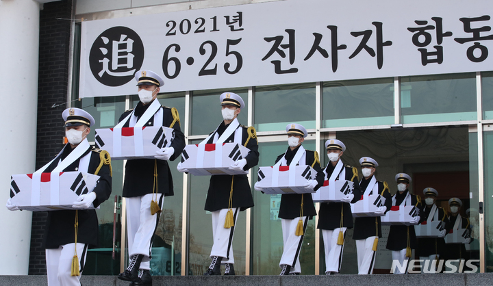 [서울=뉴시스] 배훈식 기자 = 2021년 6·25전사자 발굴유해 합동 봉안식이 열린 20일 오전 서울 동작구 국립서울현충원 현충관에서 국군 장병들이 영현 봉송을 하고 있다.(공동취재사진) 2021.12.20. photo@newsis.com