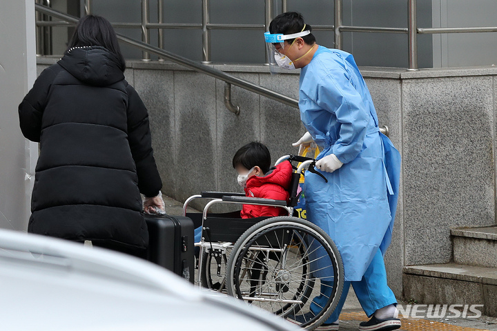 [서울=뉴시스] 백동현 기자 = 지난해 12월 20일 서울 종로구 서울대학교병원에서 의료진이 음성 확인을 받은 보호자와 함께 코로나19 확진 어린이를 중환자실로 이송하고 있다. 2022.01.20. livertrent@newsis.com