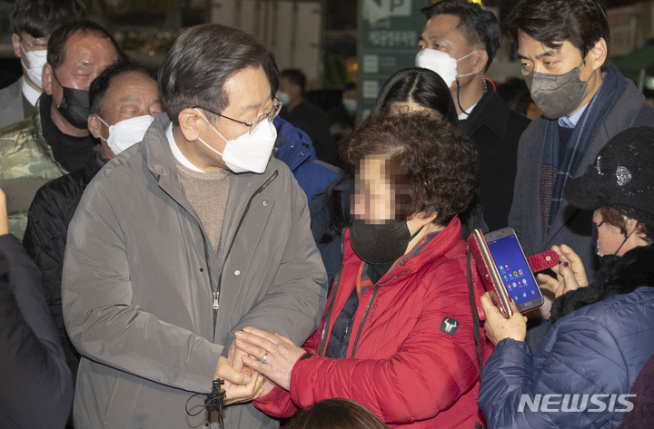 [서울=뉴시스] 국회사진기자단 = 이재명 더불어민주당 대선후보가 20일 청량리 청과물시장을 방문해 상인들과 이야기를 나누고 있다. 청량리 청과물시장은 지난주말 화재로 점포 13곳이 불에 탔다. 2021.12.20. photo@newsis.com