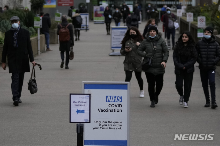 [런던=AP/뉴시스] 20일(현지시간) 영국 런던에서 시민들이 세인트 토머스 병원 코로나19 백신 접종소 인근을 지나고 있다. 영국의 코로나19 신규 확진자 수가 9만1743명으로 역대 두 번째를 기록하면서 영국 정부는 방역 강화를 놓고 논의하는 것으로 알려졌다. 2021.12.21.