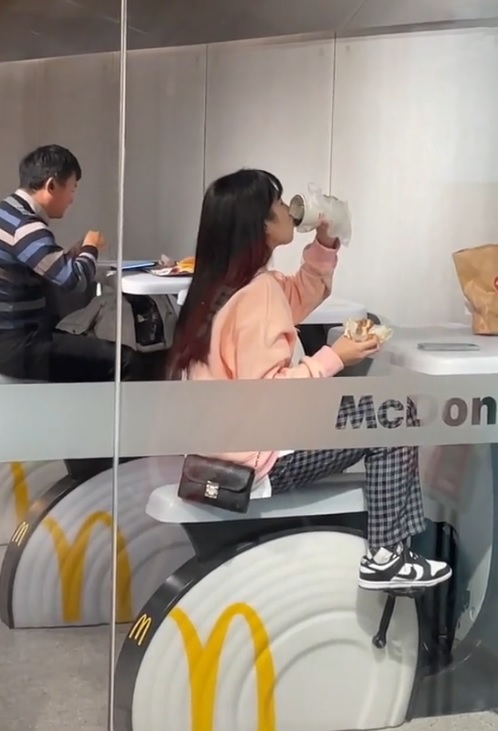 [서울=뉴시스] 지난 17일 소셜미디어(SNS)에 올라온 영상 속 장면에서 한 여성이 맥도날드에서 식사를 하며 실내 사이클을 타고 있다. (출처 : 틱톡 영상 캡처) 2021.12.22. *재판매 및 DB 금지