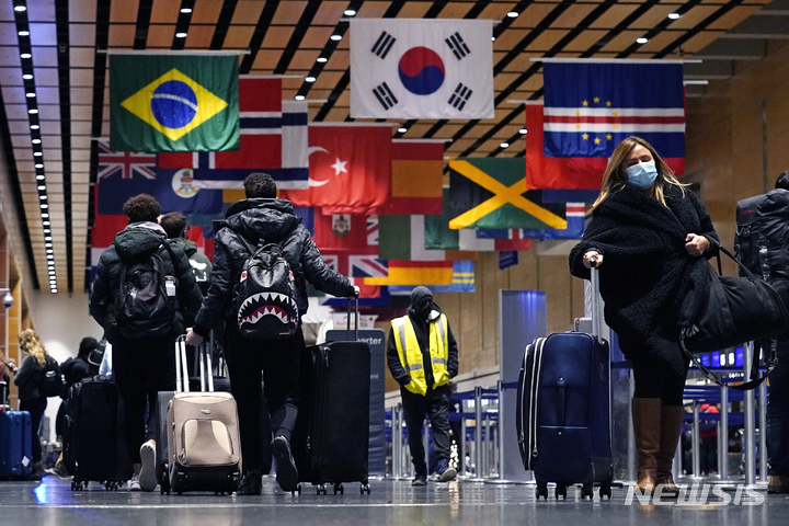 [보스턴=AP/뉴시스] 21일(현지시간) 미 매사추세츠주 보스턴의 로건 공항 E 터미널에서 여행객들이 이동하고 있다. 2021.12.22.