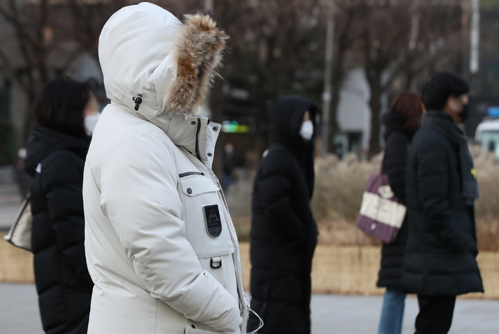 [서울=뉴시스] 조수정 기자 = 오전 기온이 어제보다 5도 이상 떨어진 영하의 추위를 기록한 지난 22일 서울 세종로네거리에서 두꺼운 옷차림을 한 시민들이 출근하고 있다. 2021.12.22. chocrystal@newsis.com