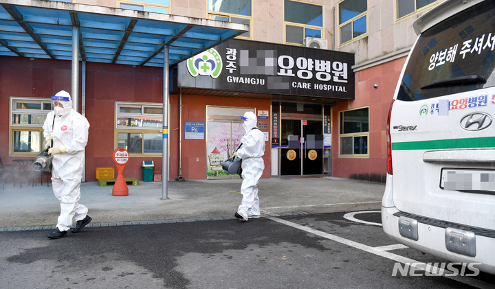 [광주=뉴시스] 류형근 기자 = 22일 오전 광주 북구 모 요양병원 앞에서 북구방역당국이 코로나19 소독·방역을 하고 있다. 요양병원에서는 이틀동안 24명의 확진자가 발생해 동일집단 격리 조치됐다. 2021.12.22. hgryu77@newsis.com