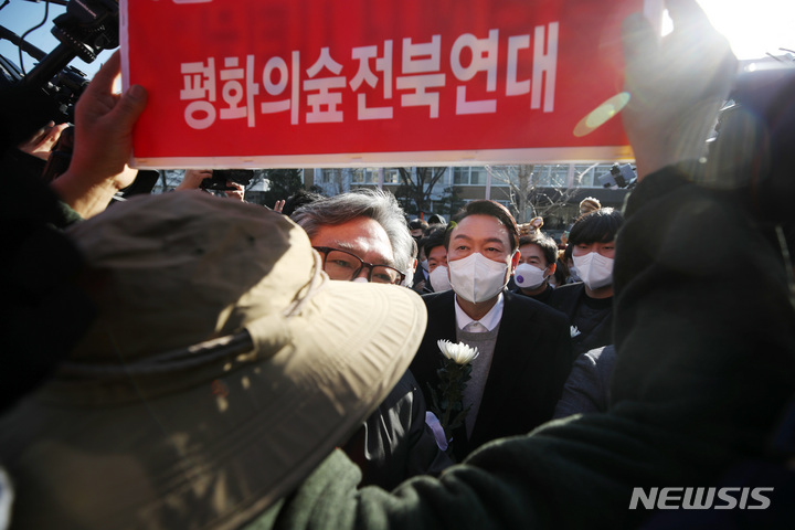 [전주=뉴시스] 전신 기자 = 윤석열 국민의힘 대선 후보가 22일 전북 전주 덕진구 전북대학교에서 전북대 민주동문회 회원 등에게 이세종 열사 추모비 참배를 저지 당하고 있다. 2021.12.22. photo1006@newsis.com