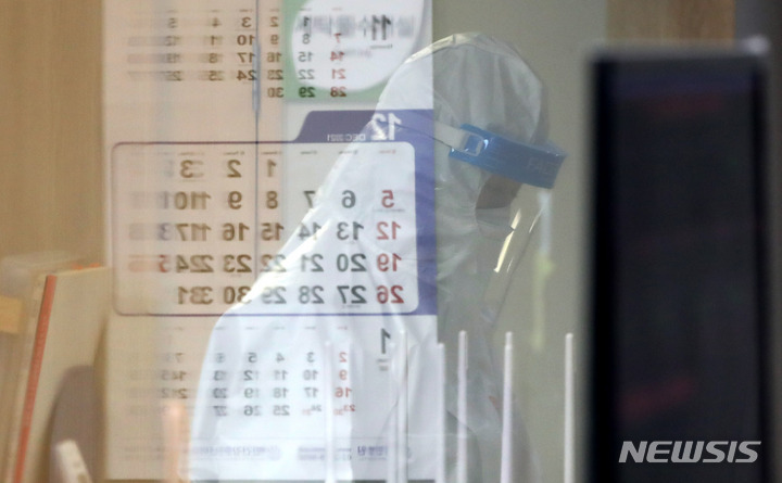 [서울=뉴시스] 추상철 기자 = 22일 오후 코로나19 거점전담병원인 서울 광진구 혜민병원 음압병동에서 업무를 보고 있는 의료진에 달력이 비치고 있다. 2021.12.22. scchoo@newsis.com