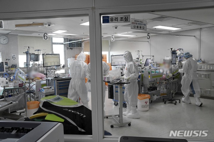 [고양=뉴시스] 배훈식 기자 = 지난 22일 오후 경기 고양시 국민건강보험공단 일산병원(코로나19 거점전담병원) 의료진이 코로나19 중환자와 위중증 환자 집중 치료실에서 환자들을 돌보고 있다. (공동취재사진) 2021.12.22. photo@newsis.com