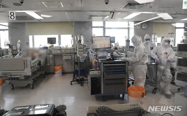 [고양=뉴시스] 배훈식 기자 = 지난 22일 오후 경기 고양시 국민건강보험공단 일산병원(코로나19 거점전담병원) 의료진이 코로나19 중환자와 위중증 환자 집중 치료실에서 환자들을 돌보고 있다. (공동취재사진) 2021.12.22. photo@newsis.com