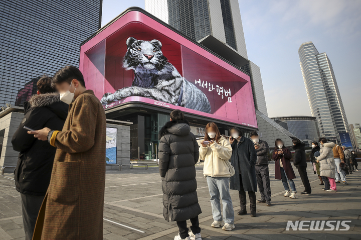 [서울=뉴시스] 정병혁 기자 = 지난 23일 오후 서울 강남구 코엑스 대형 전광판에서 상영중인 2022년 맞이 흑호 미디어아트 앞으로 삼성역 임시선별진료소를 찾은 시민들이 코로나19 검사를 받기 위해 줄 서 있다. 2021.12.23. jhope@newsis.com