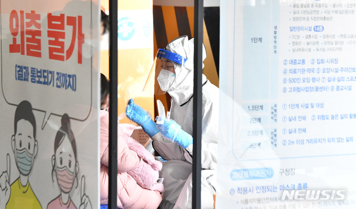 [광주=뉴시스] 변재훈 기자 = 성탄절을 이틀 앞둔 23일 오후 광주 북구선별진료소에서 한 어린이가 코로나19 검체를 채취하고 있다. 2020.12.23. wisdom21@newsis.com