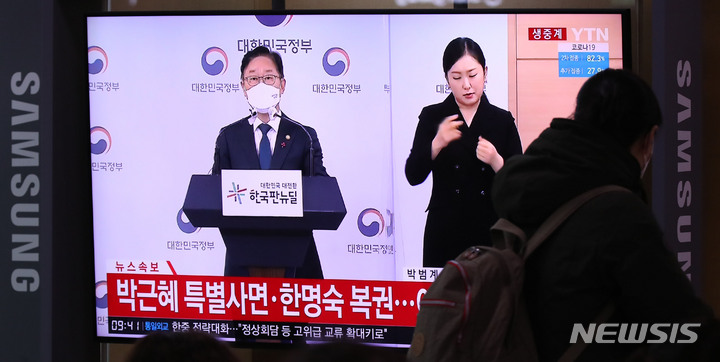 [서울=뉴시스] 고범준 기자 = 24일 오전 서울역 대합실에서 시민들이 박근혜 전 대통령에 대한 특별사면 관련 방송을 시청하고 있다. 2021.12.24. bjko@newsis.com