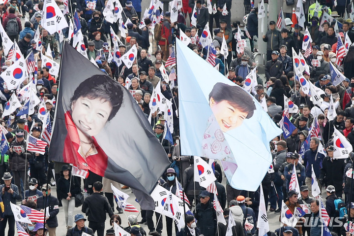 【서울=뉴시스】박미소 수습기자 =박근혜 전 대통령이 탄핵심판에서 파면 선고를 받은 지 2년을 맞은 10일 오후 서울 중구 서울역 앞에서 박 전 대통령의 석방 촉구 집회에서 태극기 사이로 박근혜 전 대통령의 현수막이 보이고 있다. 2019.03.10. misocamera@newsis.com