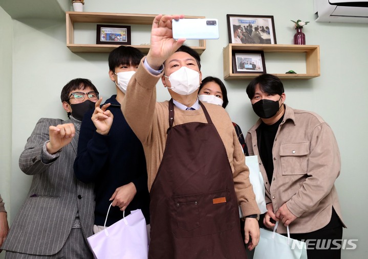 [서울=뉴시스] 국회사진기자단 = 윤석열 국민의힘 대선 후보가 24일 서울 구로구 고아권익연대를 찾아 시설 퇴소 청년들에게 선물을 전달하고 있다. 2021.12.24. photo@newsis.com
