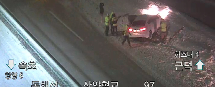 [양양=뉴시스] 김경목 기자 = 많은 눈이 내린 24일 오후 여성 운전자가 몰던 승용차가 강원 양양군 상양혈리 동해고속도로 강릉 방향 상양혈교에서 미끄러져 한국도로공사 강릉지사 관계자들의 도움을 받고 있다. (사진=한국도로공사 로드플러스 CCTV 캡처) 2021.12.15. photo@newsis.com *재판매 및 DB 금지
