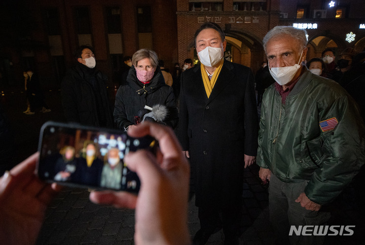 [서울=뉴시스] 정병혁 기자 = 윤석열 국민의힘 대선후보가 24일 오후 서울 중구 명동성당에서 열린 성탄절 미사에 참석하기에 앞서 시민들과 기념촬영을 하고 있다. (공동취재사진) 2021.12.25. photo@newsis.com