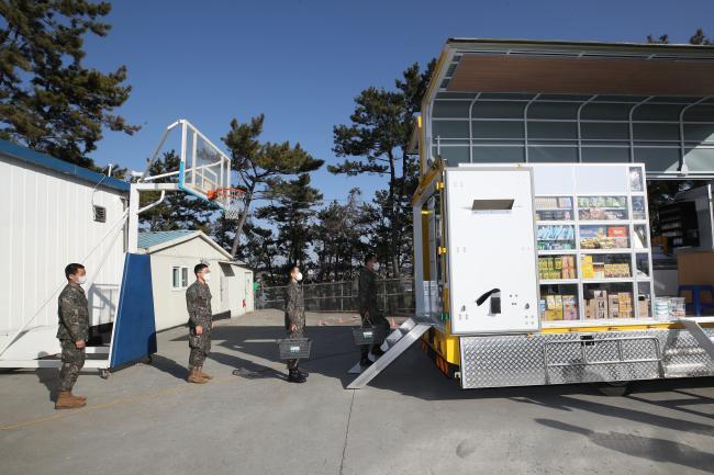 [서울=뉴시스] 해안대대 예하 소초 장병들이 필요한 물품을 구매하기 위해 이동마트 차량 앞에 줄 서 있다. 2021.12.27. (사진=국방일보 양동욱 기자 제공) *재판매 및 DB 금지